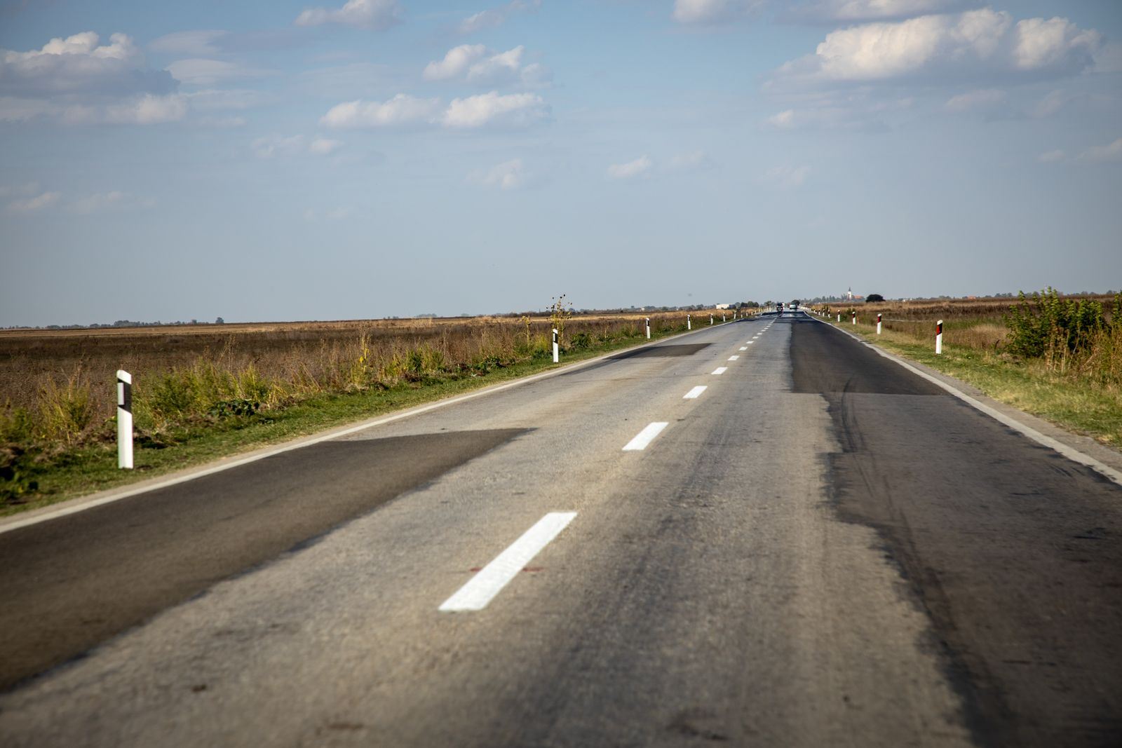 Fresh asphalt road with bold yellow center lines